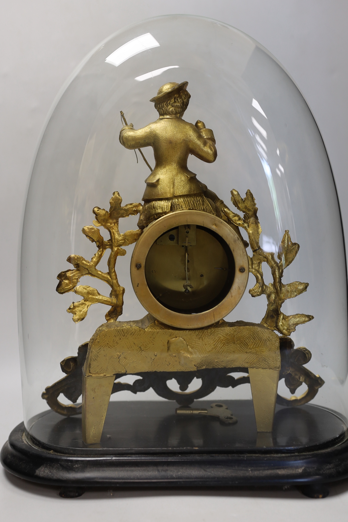 A an ornate figural gilt-spelter mantel clock, under glass dome on stand, 40cm high